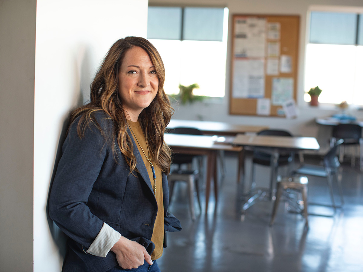 A teacher standing by their classroom for the first day of school.